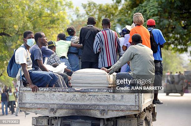 Group of Haitians transport a coffin in the back of a truck along a street in Port-au-Prince on January 14 following the devastating earthquake that...