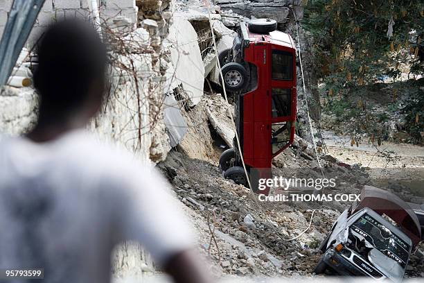Man observes destoyed cars in the center of Port-au-Prince, on January 14 following the devastating earthquake that rocked Haiti on January 12....
