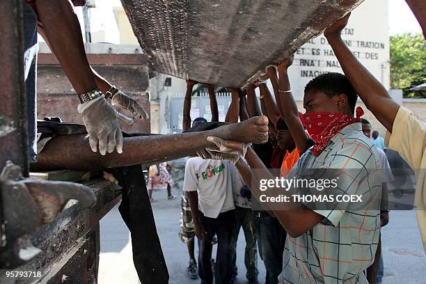 People carry a body to a truck in Port au Prince on January 14 following the devastating earthquake that rocked Haiti on January 12. Desperate...