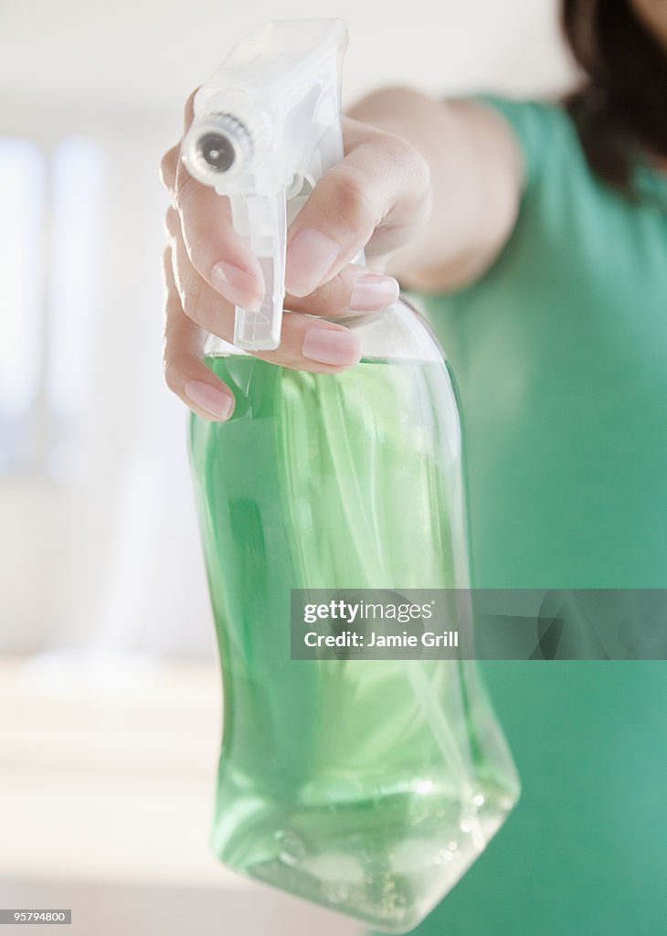 Woman using green cleaning spray