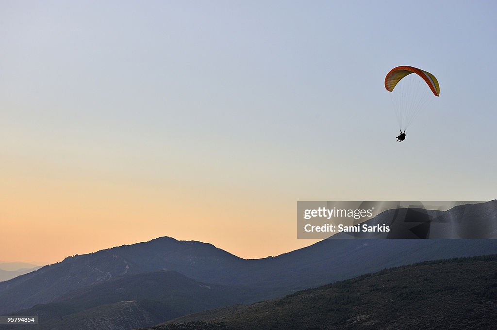 Paraglider flying in tandem, at sunset