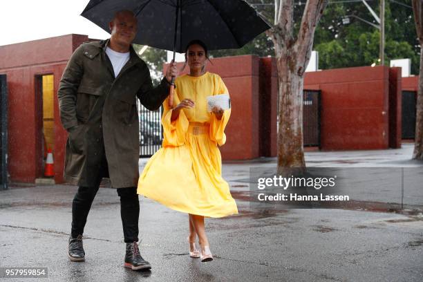 Michael Klim wearing khaki parka jacket and Desiree Deravi wearing yellow dress during Mercedes-Benz Fashion Week Resort 19 Collections at Royal Hall...