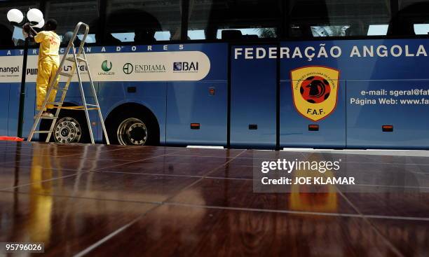 Hotel worker cleans a light next to the bus of Angolan national football team in hotel Calor Tropical during the African Cup of Nations football...