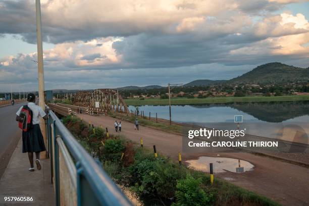 Schoolgirl walks along the new Chinese built bridge on the river Congo on April 20, 2018. - The bridge runs parallel to the old one along which the...