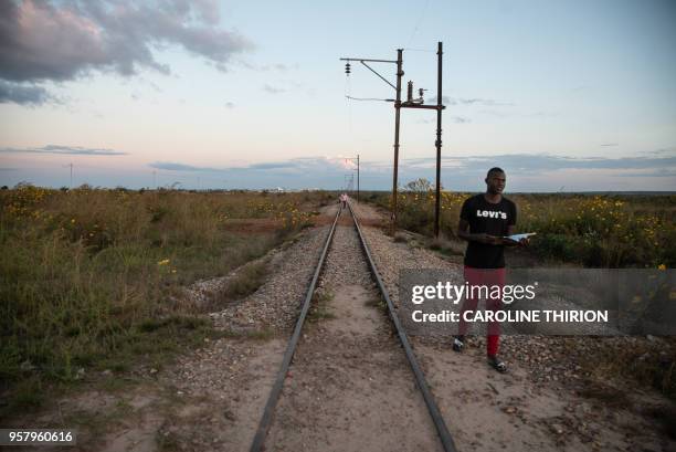 Man walks along the railway line near the airport in Kolwezi on May 7, 2018. - The airport was the site of the battles for Kolwezi, in May 1978...