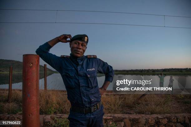 Congolese policeman poses along the railway that runs parallel to river Congo on April 20, 2018. - The historical battle of Kolwezi was fought in May...