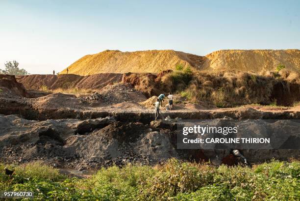 Miners are seen on the banks of a large mine embankment on April 23, 2018 in Kolwezi. - The historical battle of Kolwezi was fought in May 1978 by...