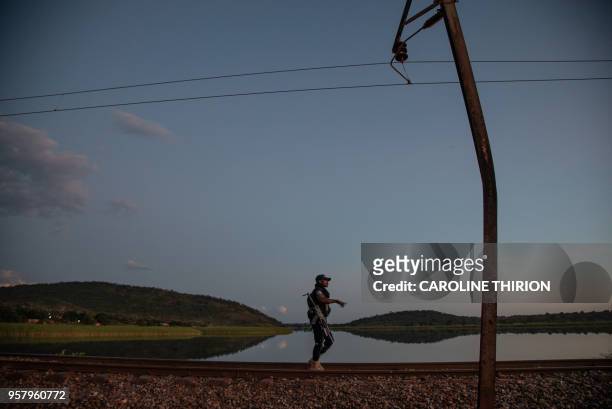 Congolese policeman walks along the railway that runs parallel to river Congo on April 20, 2018. - The historical battle of Kolwezi was fought in May...