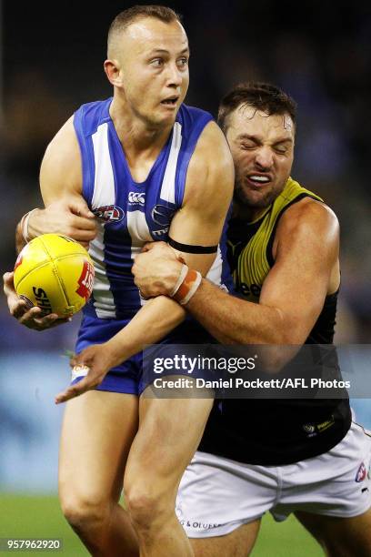 Billy Hartung of the Kangaroos is tackled by Toby Nankervis of the Tigers for the ball during the 2018 AFL round eight match between the North...