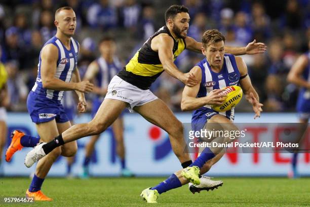 Shaun Higgins of the Kangaroos is tackled by Shane Edwards of the Tigers during the 2018 AFL round eight match between the North Melbourne Kangaroos...
