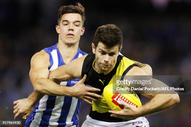 Trent Cotchin of the Tigers is tackled by Jy Simpkin of the Kangaroos during the 2018 AFL round eight match between the North Melbourne Kangaroos and...