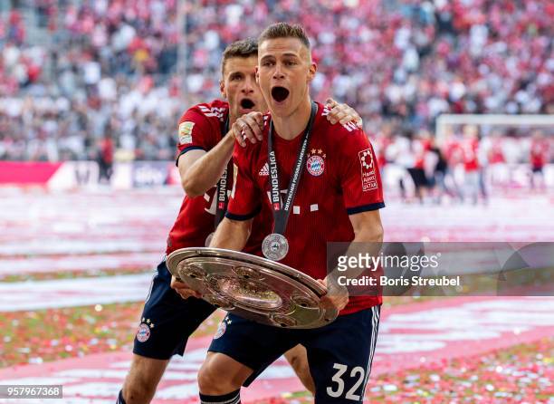 Joshua Kimmich of FC Bayern Muenchen lifts the trophy to celebrate the 28th German football championship after the Bundesliga match between FC Bayern...