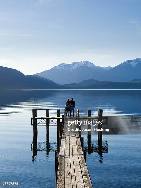 young couple standing on lake jetty  - テアナウ ストックフォトと画像