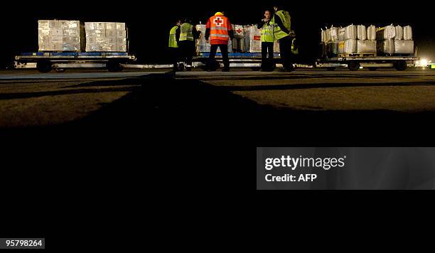 Humanitarian material is loaded on a plane chartered by the Spanish Red Cross ready to take off from the tarmac of Barcelona's airport to Haiti on...