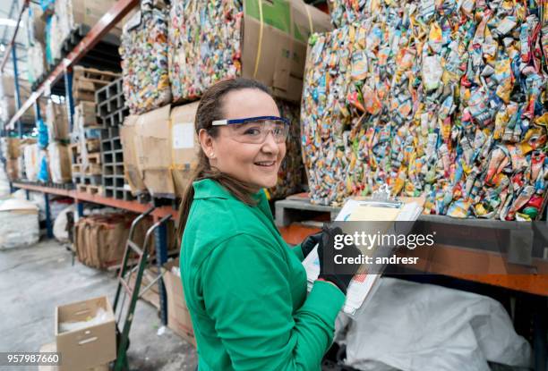 donna che lavora in una fabbrica di riciclaggio - centro di riciclaggio foto e immagini stock