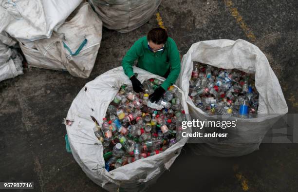 frau arbeitet in einem recycling-center - wiederverwertungsanlage stock-fotos und bilder