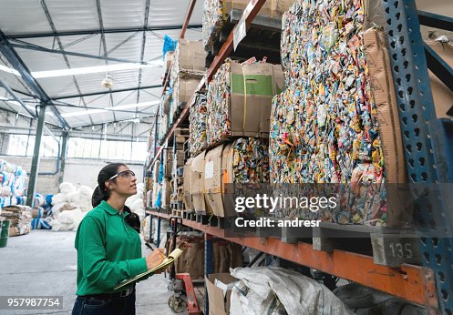 Mulher que trabalha numa fábrica de reciclagem Mulher que trabalha numa fábrica de reciclagem