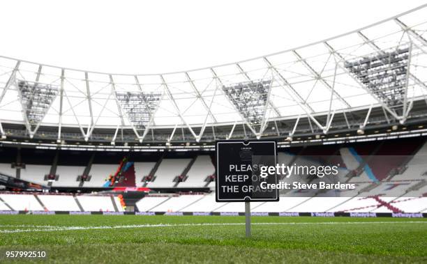 Please keep off the grass' sign is seen prior to the Premier League match between West Ham United and Everton at London Stadium on May 13, 2018 in...