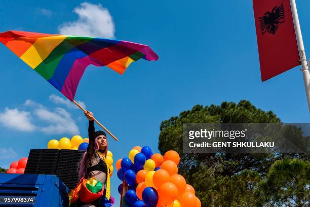 An Albanian LGBT activist waves a rainbow flag as she attends Tirana Gay Pride to mark the International Day Against Homophobia and Transphobia on...