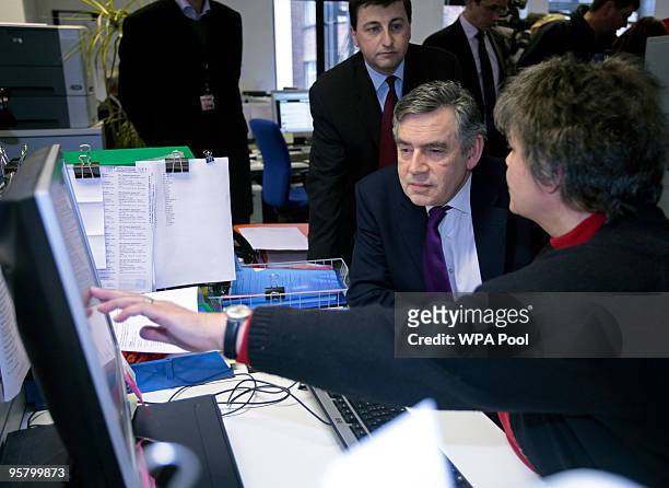 British Prime Minister Gordon Brown speaks with fund raising manager Pat Willson, while visiting the Disasters Emergency Comittee on January 15, 2010...