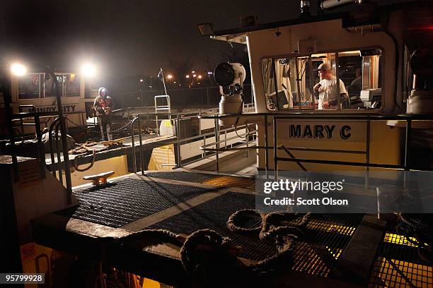 Capt. Robbie Hess pilot of Illinois Marine Towing's Mary C picks up a tow from the crew of the Windy City tow boat January 14, 2010 near Lemont,...