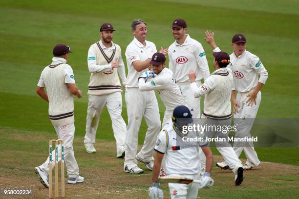 Rikki Clarke of Surrey celebrates with his teammates after dismissing Jack Leaning of Yorkshire during day three of the Specsavers County...