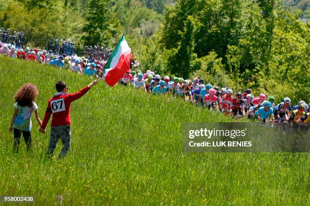 Boys waves an Italian flag as the pack rides during the 9th stage between Pesco Sannita and the Gran Sasso during the 101st Giro d'Italia, Tour of...