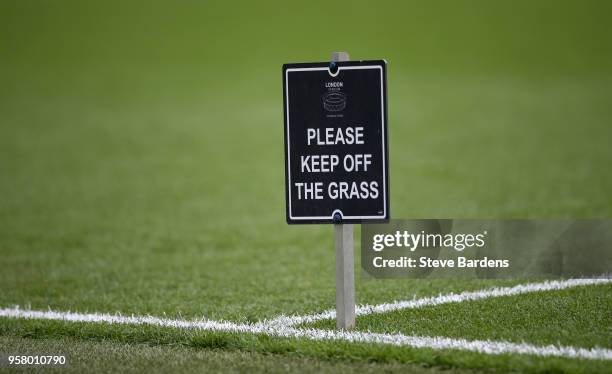 Please keep off the grass' sign is seen on the pitch prior to the Premier League match between West Ham United and Everton at London Stadium on May...