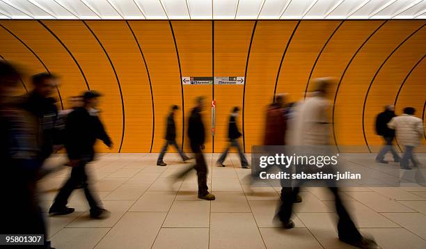 unrecognizable commuters at an orange underground - subway station stockfoto's en -beelden