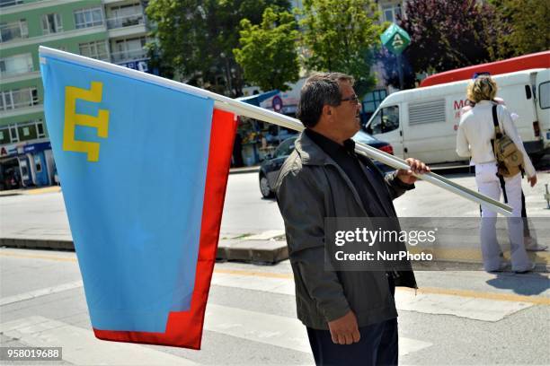 Man holds flags during a mourning rally marking the Deportation of the Crimean Tatars in Ankara, Turkey, on Sunday, May 13, 2018. A total of 238,500...