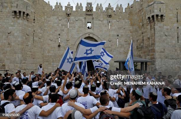 Israeli nationalist settlers wave their national flag as they celebrate the Jerusalem Day at the Old City's Damascus gate in Jerusalem on May 13,...