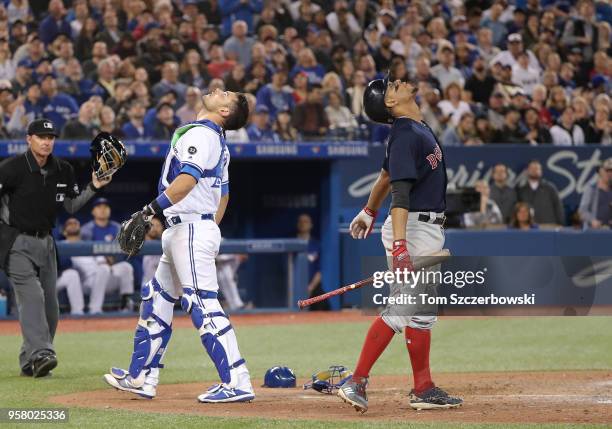 Luke Maile of the Toronto Blue Jays camps underneath a pop up before catching it in the eighth inning during MLB game action as Xander Bogaerts of...