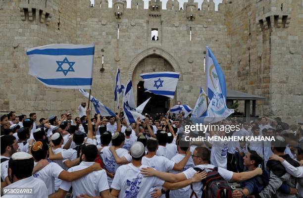 Israeli nationalist settlers wave their national flag as they celebrate the Jerusalem Day at the Old City's Damascus gate in Jerusalem on May 13,...