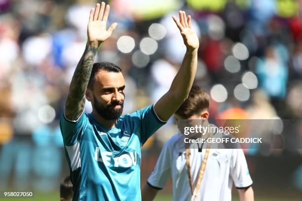 Swansea City's English midfielder Leon Britton waves as he plays his final match for Swansea before the English Premier League football match between...