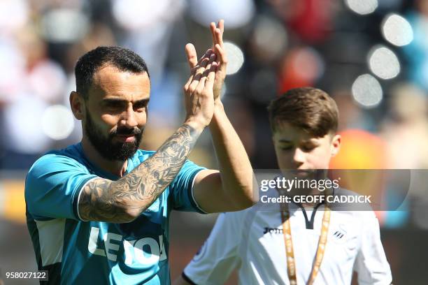 Swansea City's English midfielder Leon Britton waves as he plays his final match for Swansea before the English Premier League football match between...