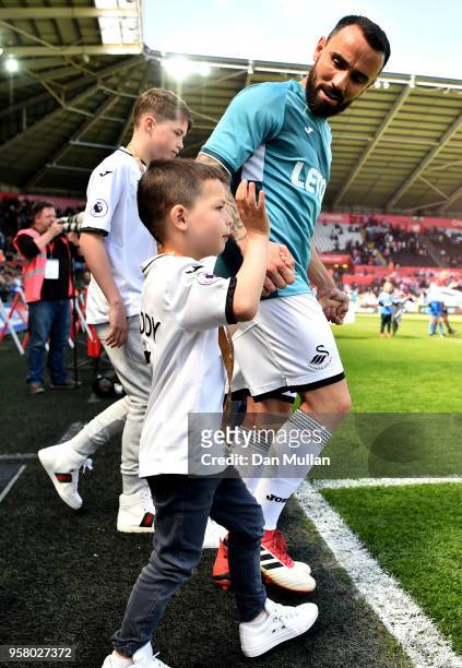 Leon Britton of Swansea City walks out on the pitch with his son prior to the Premier League match between Swansea City and Stoke City at Liberty...