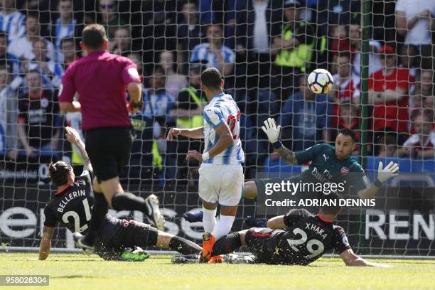 Huddersfield Town's English midfielder Tom Ince shoots toward Arsenal's Colombian goalkeeper David Ospina during the English Premier League football...