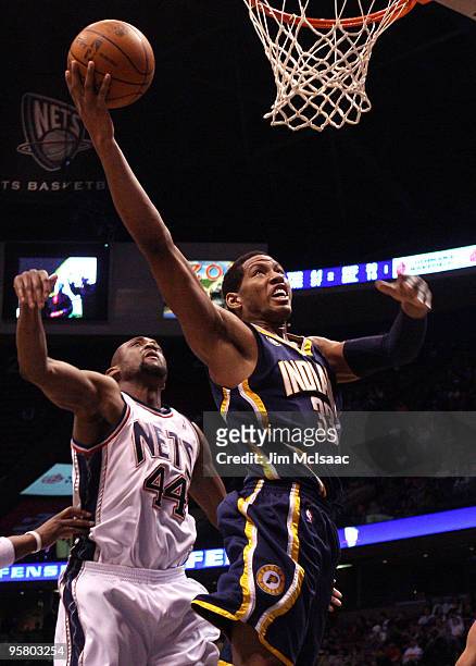 Danny Granger of the Indiana Pacers drives to the hoop for a basket against Trenton Hassell of the New Jersey Nets at the Izod Center on January 15,...