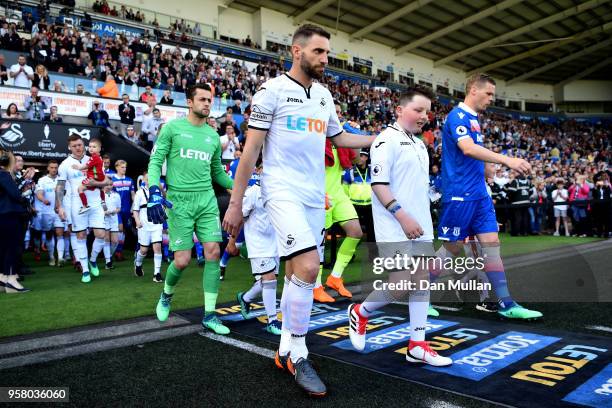 Angel Rangel of Swansea City leads the two sides out during the Premier League match between Swansea City and Stoke City at Liberty Stadium on May...