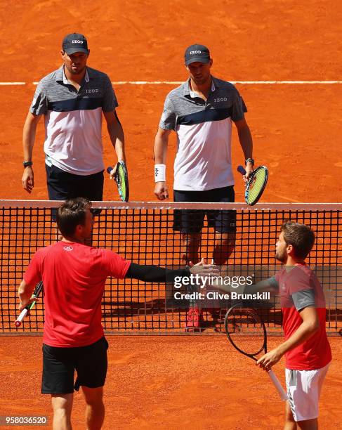 Bob Bryan and Mike Bryan of the United States shake hands at the net after retiring in the first set due to Bob Bryan receiving an injury playing...