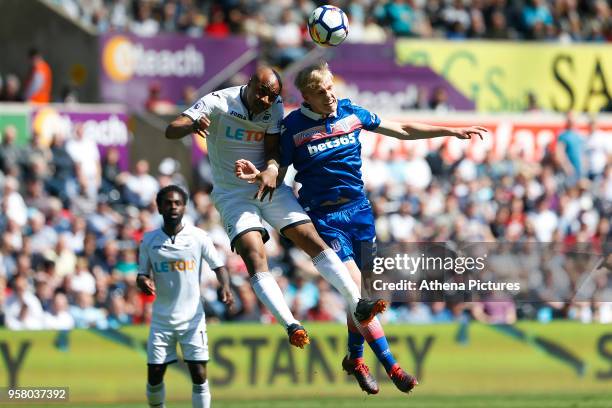 Andre Ayew of Swansea City contends with Kevin Wimmer of Stoke City during the Premier League match between Swansea City and Stoke City at Liberty...