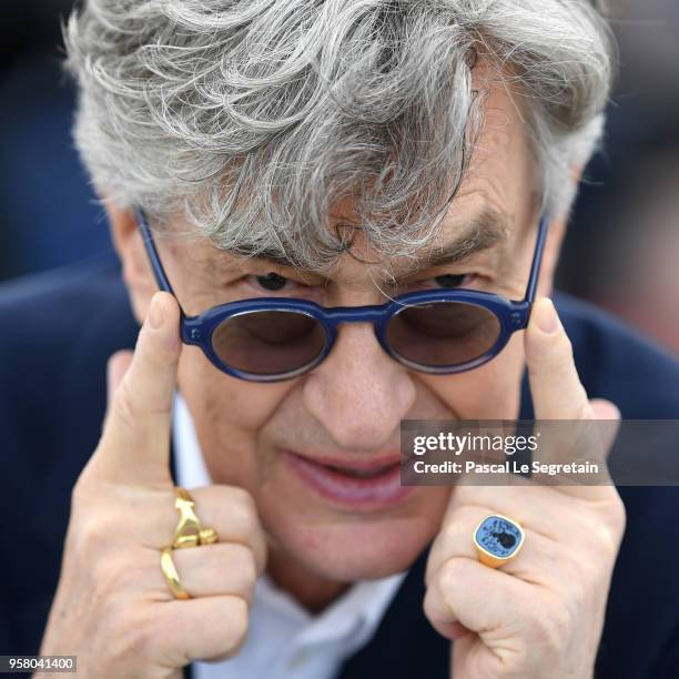 Director Wim Wenders holds his glasses up as he attends the photocall for "Pope Francis - A Man Of His Word" during the 71st annual Cannes Film...