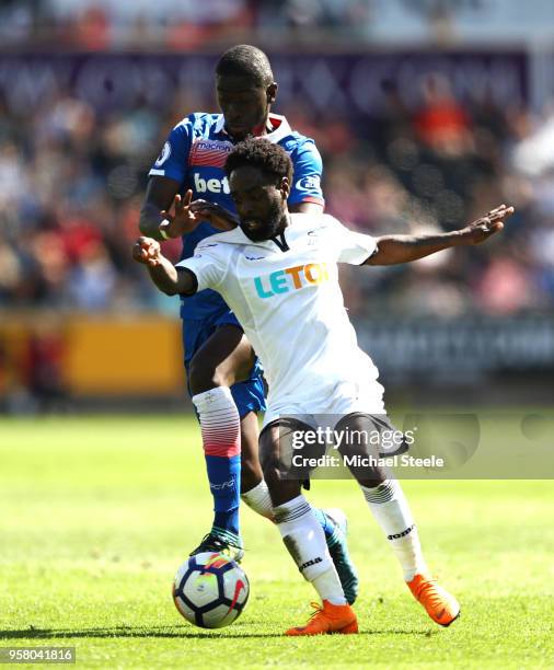 Kyle Bartley of Swansea City battles for possession with Badou Ndiaye of Stoke City during the Premier League match between Swansea City and Stoke...