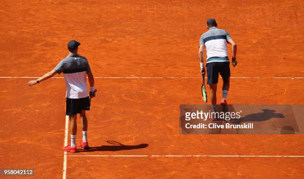 Bob Bryan of the United States walks to the baseline injured to serve, with brother Mike Bryan of the United States telling him to retire in the...