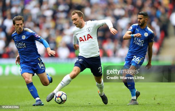 Christian Eriksen of Tottenham Hotspur controls the ball as Adrien Silva of Leicester City and Riyad Mahrez of Leicester City looks on during the...