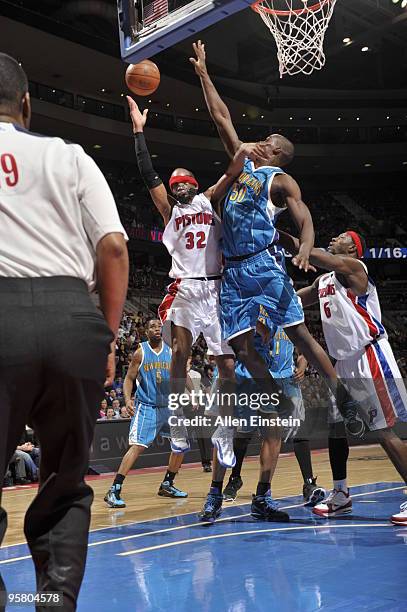 Richard Hamilton of the Detroit Pistons loses his mask and head band going up for a shot attempt against Emeka Okafor of the New Orleans Hornets in a...