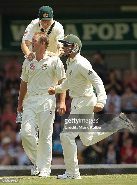 Marcus North, Nathan Hauritz and Michael Hussey of Australia celebrate taking the wicket of Shoaib Malik of Pakistan during day three of the Third...