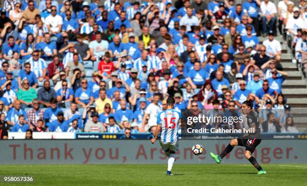 General view of match action with Chris Lowe of Hudderasfield Town and Hector Bellerin of Arsenal as an advertising board reading 'Thank you Arsene...
