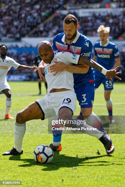 Andre Ayew of Swansea City challenged by Erik Pieters of Stoke City during the Premier League match between Swansea City and Stoke City at The...