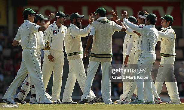 The Pakistan team celebrate Mohammad Yousuf and Mohammad Aamer of Pakistan who combined to take the wicket of Shane Watson of Australia during day...